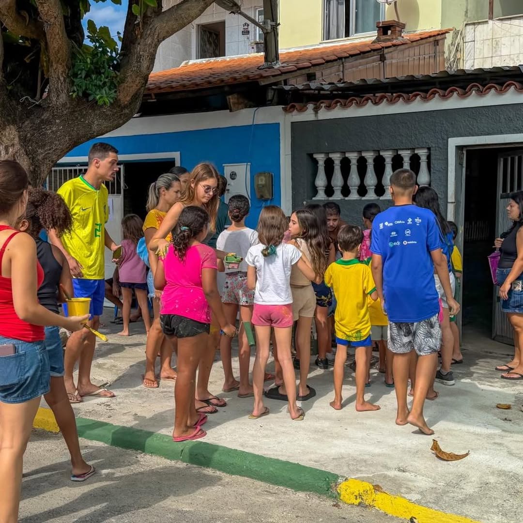 Pessoas pintando a Rua Taturana em Vicente de Carvalho para a Copa 2026